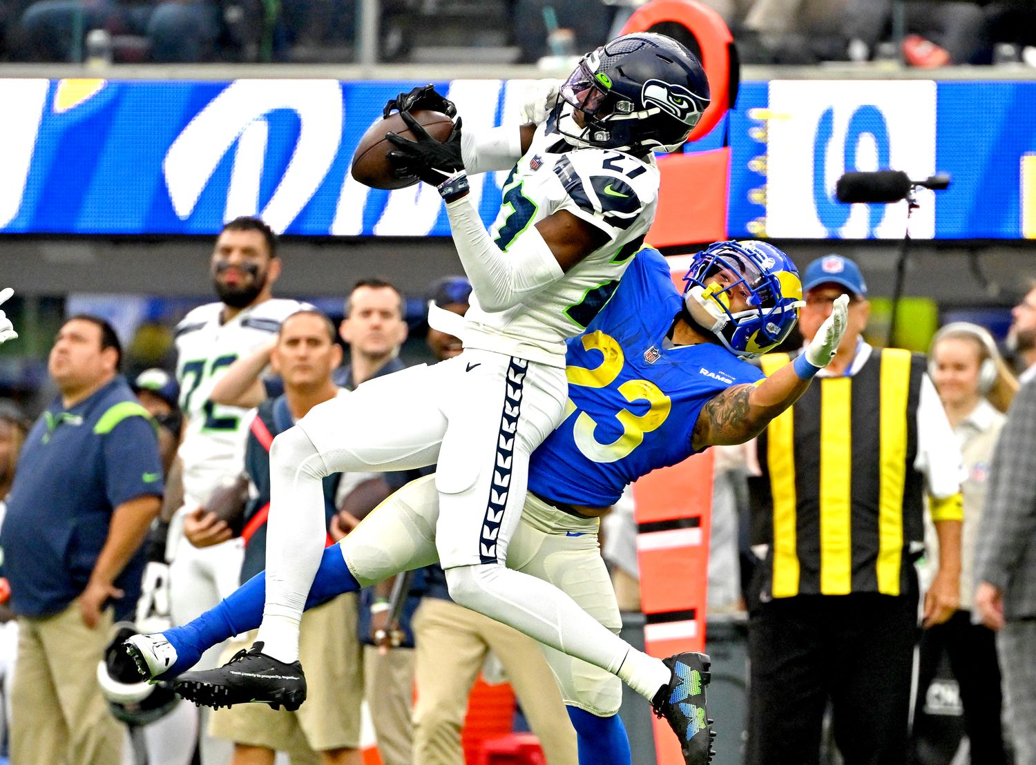 Riq Woolen jumps in front of a Rams player to catch the ball